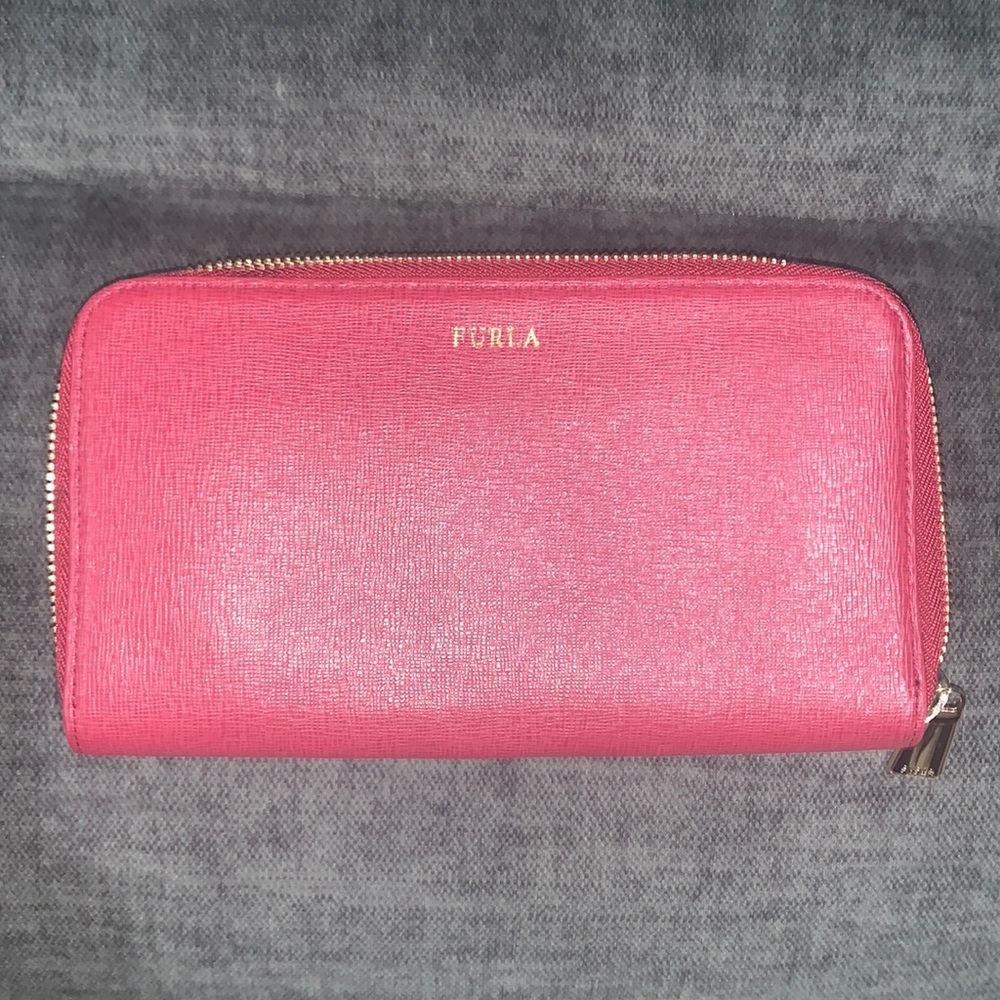Red Furla zip around wallet with card slots inside.